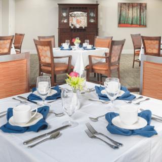 A formal dining room setup with neatly arranged tables and place settings.