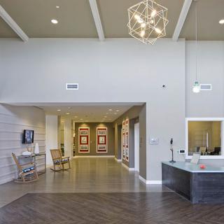 A modern lobby with a reception desk, comfortable seating, and stylish lighting.