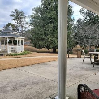 A serene outdoor view featuring a gazebo, trees, and a cozy patio setting.