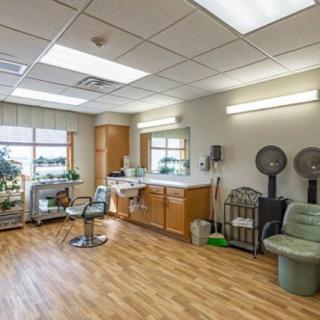 A spacious and well-lit hair salon with modern furniture and equipment.