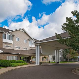 A welcoming entrance to a modern building under a partly cloudy sky.