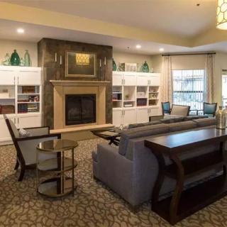A cozy living room with a fireplace, comfortable seating, and built-in bookshelves.