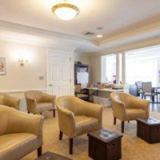 A cozy waiting room with beige chairs and a warm ambiance.