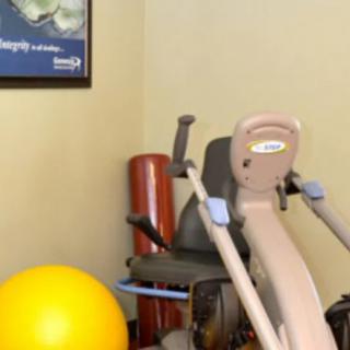 A corner of a gym with exercise equipment and therapy tools.