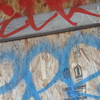 A vibrant blend of red and blue graffiti on a wooden surface.