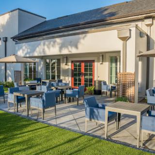 A modern outdoor patio with comfortable seating, perfect for dining in the sunlight.