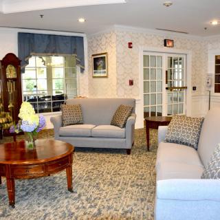 A cozy living room with sofas, a wooden coffee table, and a grandfather clock.
