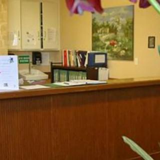 A reception desk in an office with flowers and organized folders.