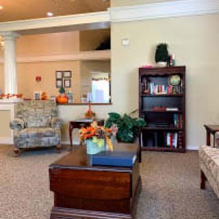 A cozy living room with a bookshelf and a coffee table decorated with flowers.