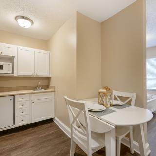 A compact kitchen and dining area with a small table and two chairs.