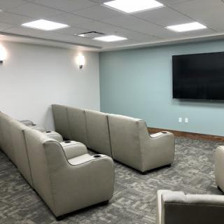A modern lounge area with comfortable seating and a large television.