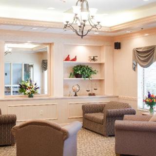 A cozy lobby area featuring comfortable seating, elegant decor, and a chandelier.
