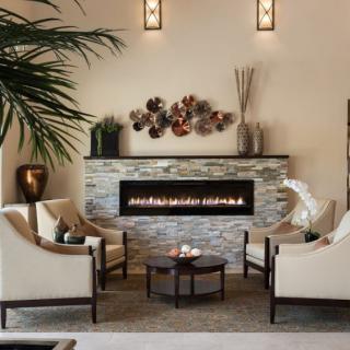 A cozy and modern living room with a stylish fireplace, surrounded by elegant chairs and a coffee table.