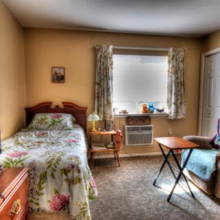 Cozy bedroom with floral bedding and a study area.