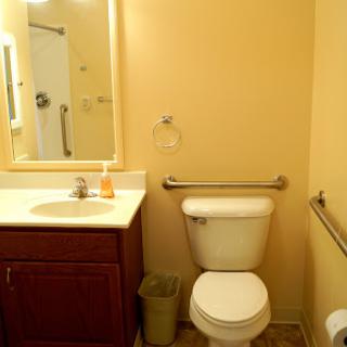 A clean and simple bathroom featuring essential fixtures like a toilet, sink, and mirror.
