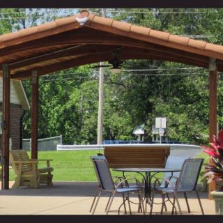 A cozy outdoor patio with a covered structure and garden views.