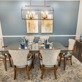 A beautifully decorated dining room featuring an elegant table setting, modern chandelier, and stylish artwork.
