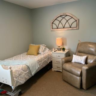 A cozy bedroom with a single bed and armchair.