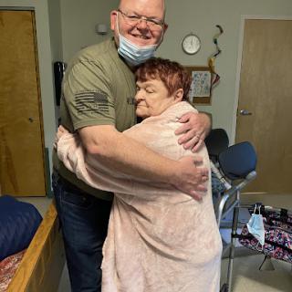 A heartfelt embrace shared between a caregiver and an elderly individual, symbolizing warmth and companionship.