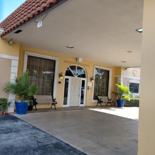 The welcoming entrance of a hotel featuring comfortable seating and tropical landscaping.