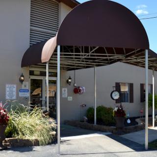 A welcoming entrance with a canopy and landscaped surroundings.