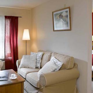 A cozy living room with a comfortable sofa, floor lamp, and a coffee table adorned with decor.