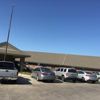 A view of a parking lot in front of a building on a sunny day.