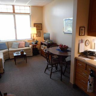 A cozy apartment living room with a sofa, table, and TV.