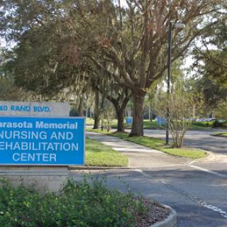 Entrance of a nursing and rehabilitation center surrounded by greenery.
