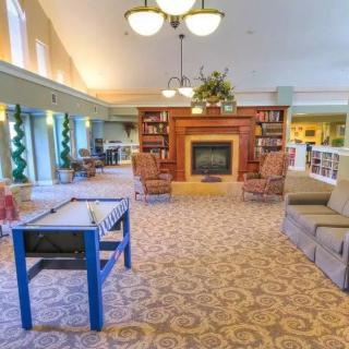 A cozy living room with a fireplace, bookshelves, and comfortable seating.