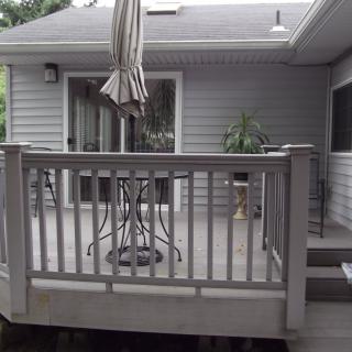 A small outdoor deck with a patio table set and an umbrella.