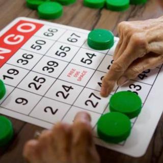 Person playing a game of bingo with green markers.