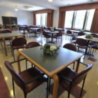 An empty dining room with neatly arranged tables and chairs.