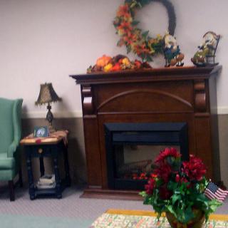 A cozy living room with a decorated fireplace and autumn accents.