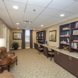 A spacious office with workstations, bookshelves, and comfortable seating.