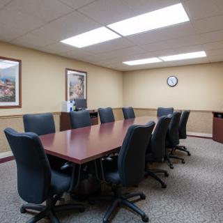 A spacious conference room equipped with a large table and comfortable chairs, perfect for meetings.