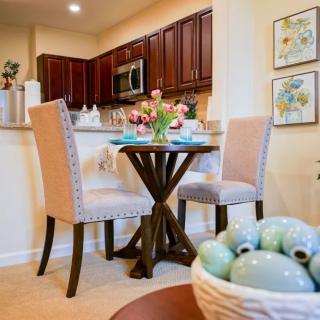 A cozy dining space in a modern kitchen with elegant decor and floral centerpiece.