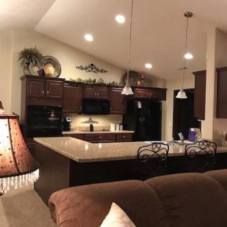 A modern and cozy kitchen with dark cabinets and pendant lighting.