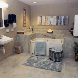 A modern bathroom with a corner bathtub, a wall-mounted sink, and stylish decor.