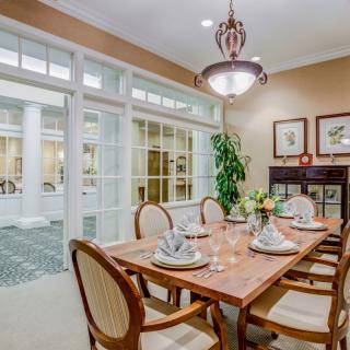 A beautifully furnished dining room with an elegantly set table and ambient lighting.
