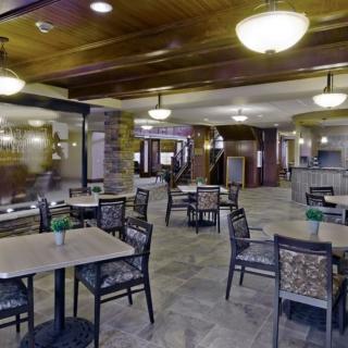 A spacious and elegantly decorated restaurant interior with tables and chairs arranged for dining.