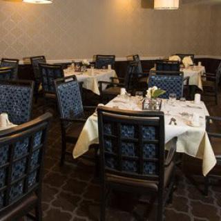 An elegant dining room with neatly set tables and plush chairs.