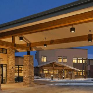 Modern building with a well-lit entrance at dusk.