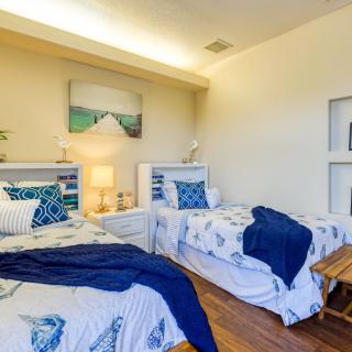 A cozy bedroom with twin beds featuring a coastal theme and blue accents.