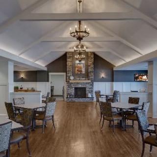 Spacious dining area with a cozy fireplace and elegant chandeliers.
