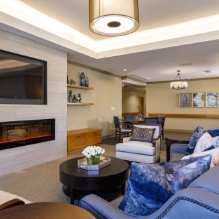A modern living room featuring a cozy seating area, fireplace, and elegant ceiling lighting.
