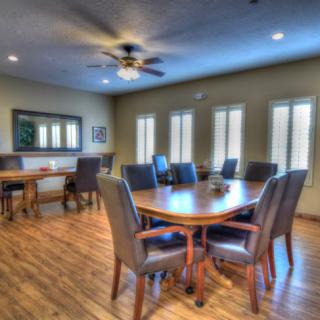 A spacious conference room with a large wooden table surrounded by chairs and natural lighting from the windows.