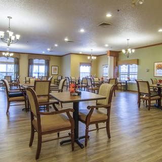 A spacious and well-lit dining room with arranged tables and chairs.