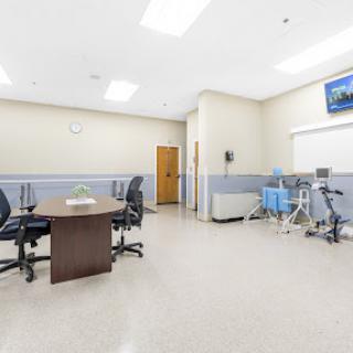 A clean and organized medical examination room equipped with essential furniture and equipment.