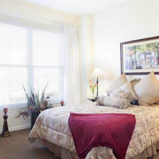 A serene and inviting bedroom featuring soft bedding, natural light, and decorative accents.